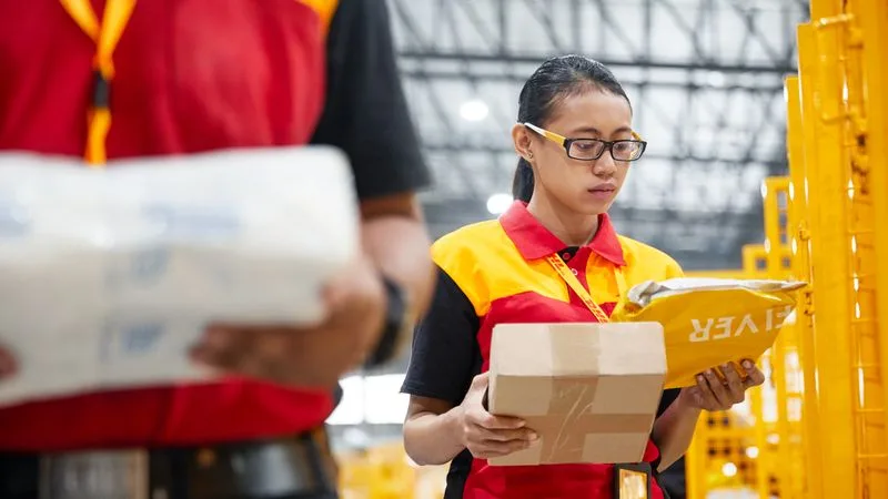 DHL Express worker checking Thailand cosmetic product parcels before international shipping