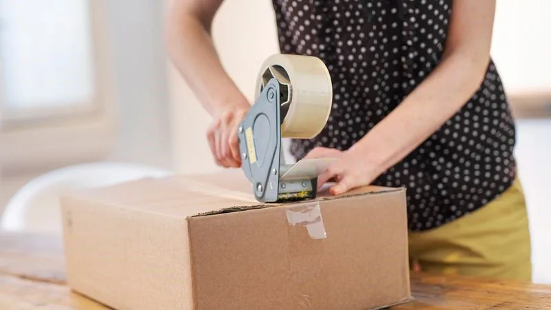 storeowner preparing a parcel for shipping overseas