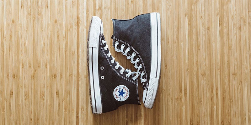 Pair of black converse on wooden floor