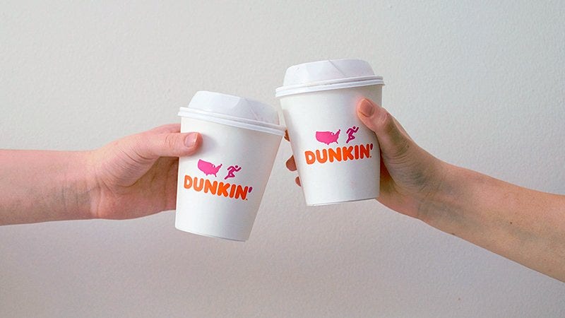 two hands holding dunkin' donuts cups