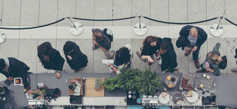 People queuing at a coffee and food counter