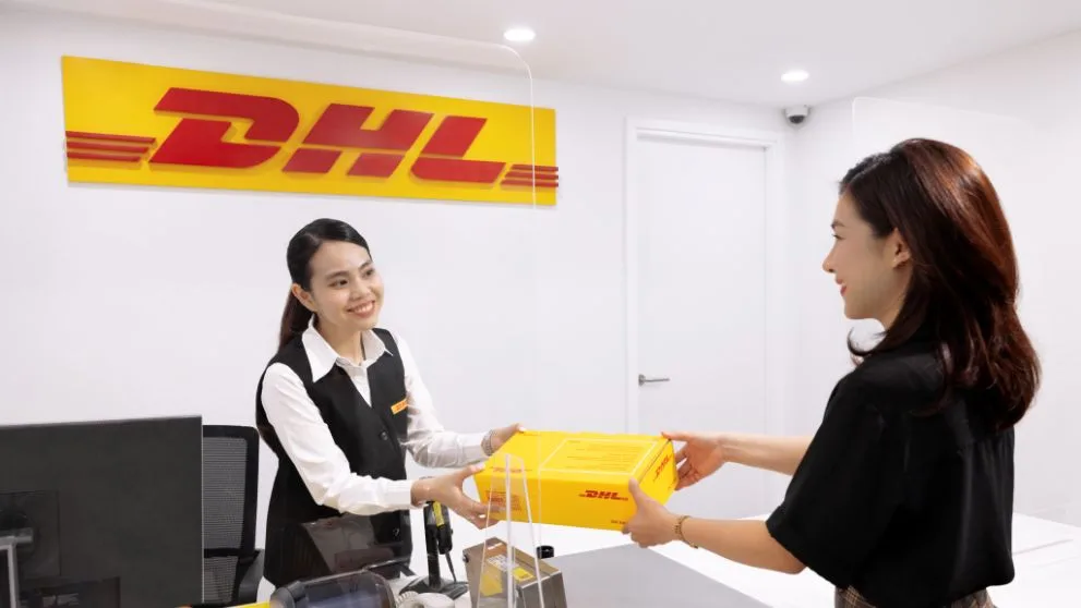 customer with shipping package being passed to a dhl express service centre