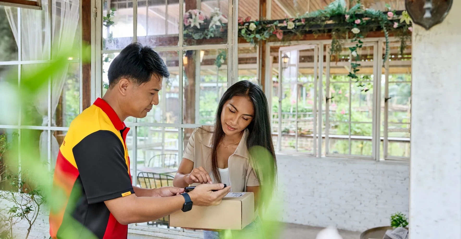 a customer and DHL employee check the DHL Express air waybill