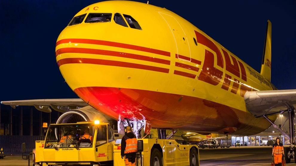 dhl workers examining dhl plane