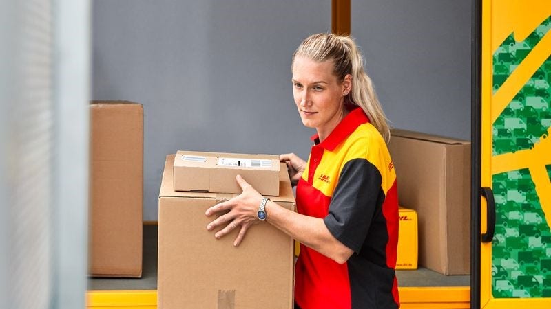 Postwoman unloads packages from van