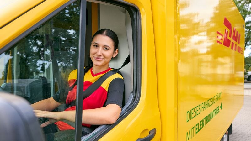 female driver sitting in DHL van to ship parcels 