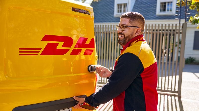 A DHL employee opening a DHL van.