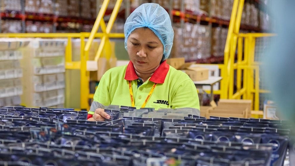 female dhl express employee packing liquids for international shipping