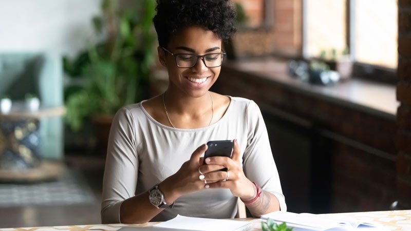 woman smiling at mobile phone