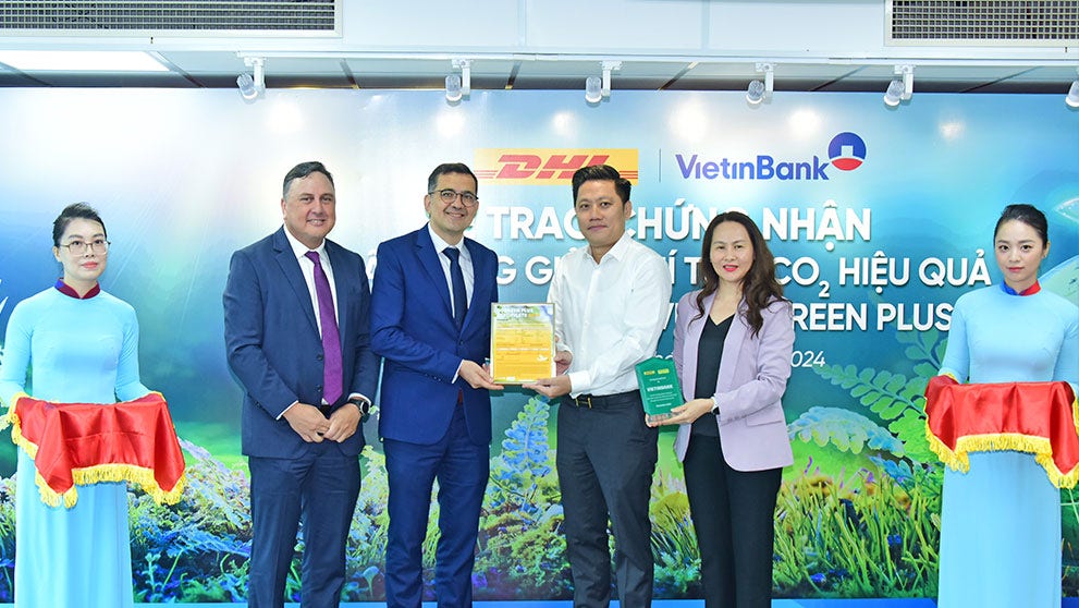 dhl express and vietinbank representatives at an event celebrating their decarbonization partnership