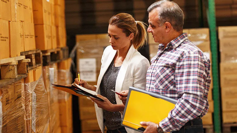 man and woman looking at clipboard