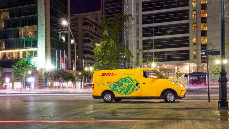 An electric DHL van is driving through the city