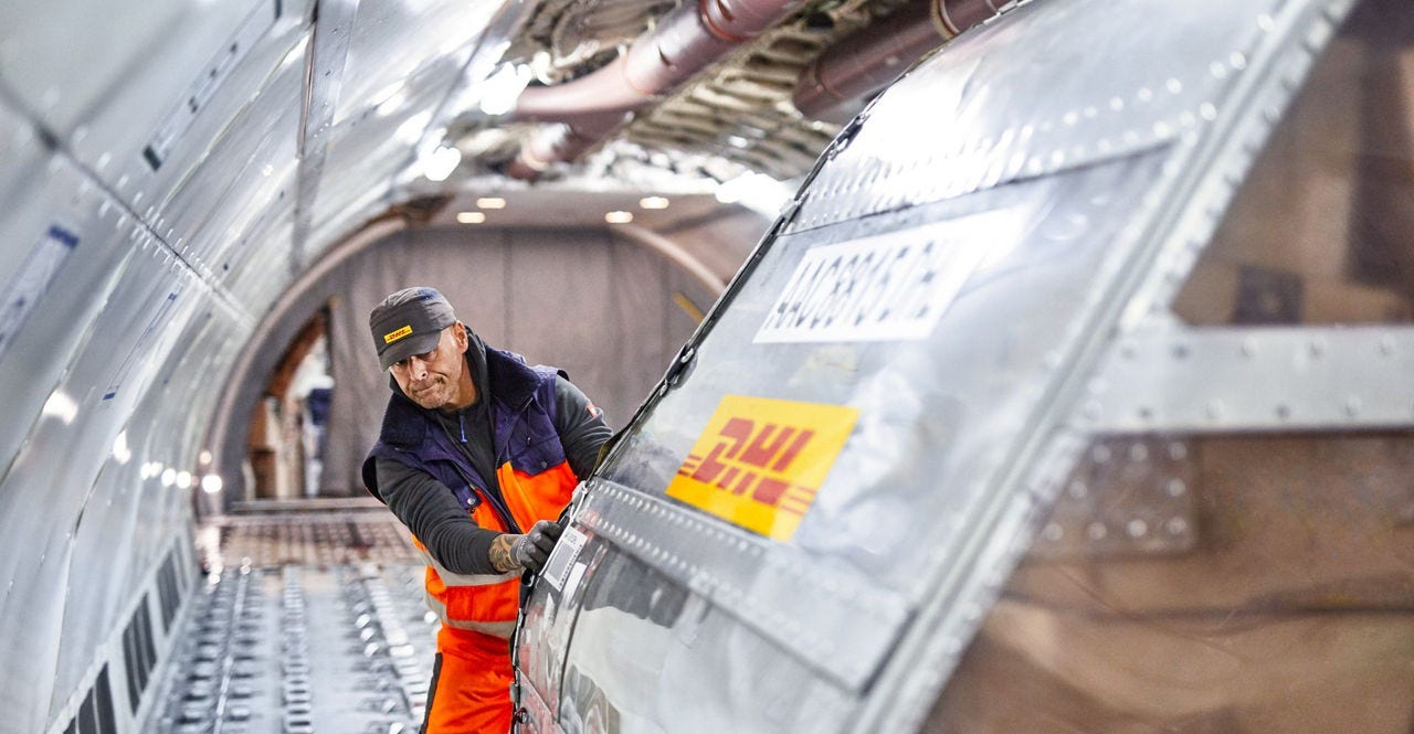 dhl express employee pushing air freight box for shipping heavy items