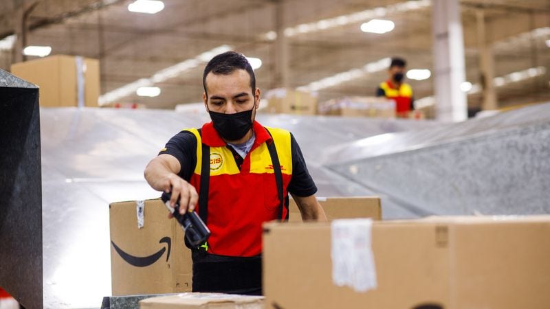 a dhl employee inspecting some returned boxes