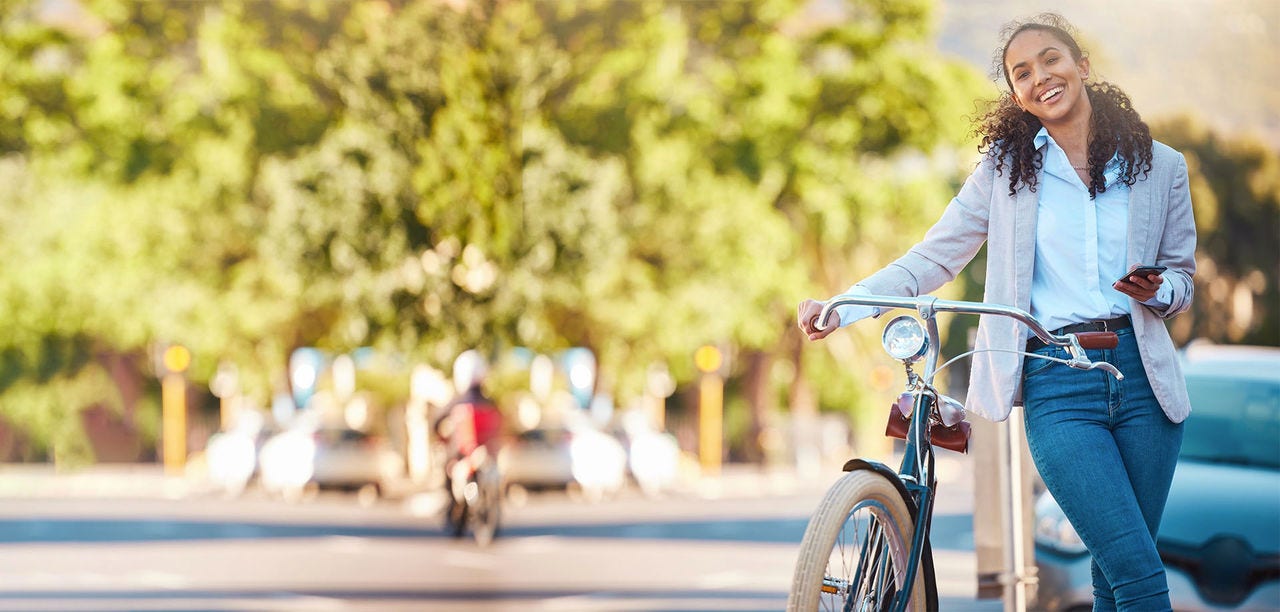 woman smiling holding a bicycle