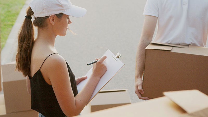 woman signing on a clipboard