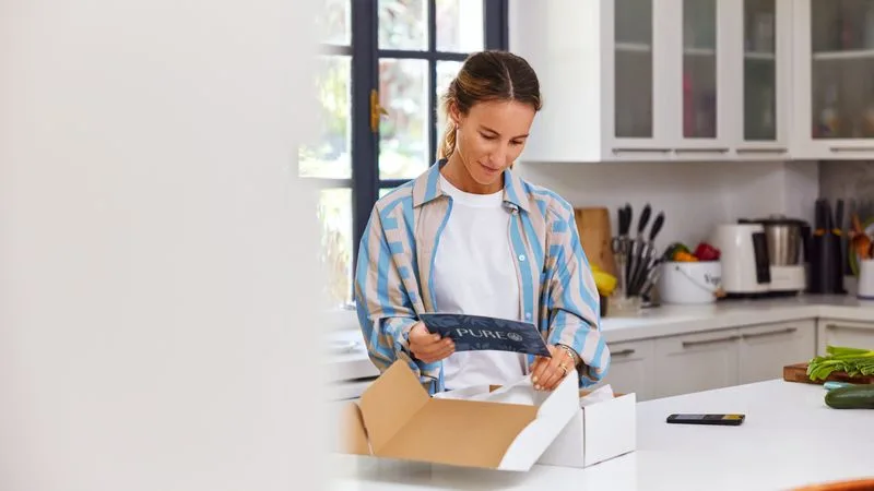 woman opening a package after te the successful completion of the last mile delivery process