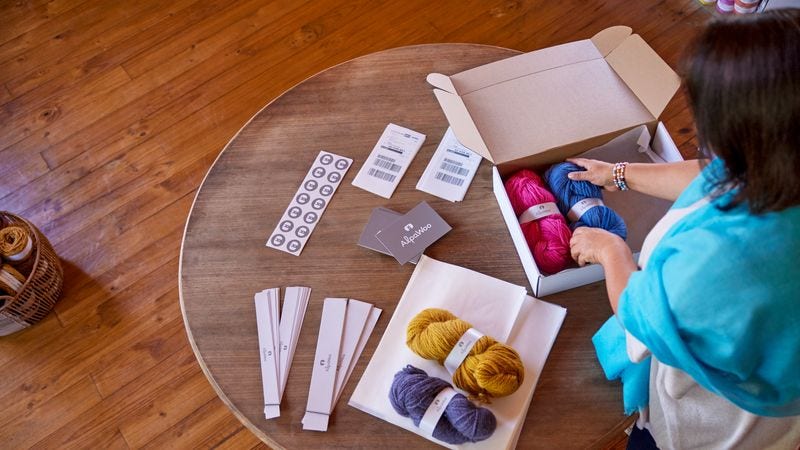 a wool shop owner is packing orders for sustainably produced wool