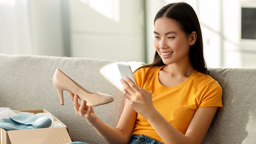 woman smiling and holding a shoe