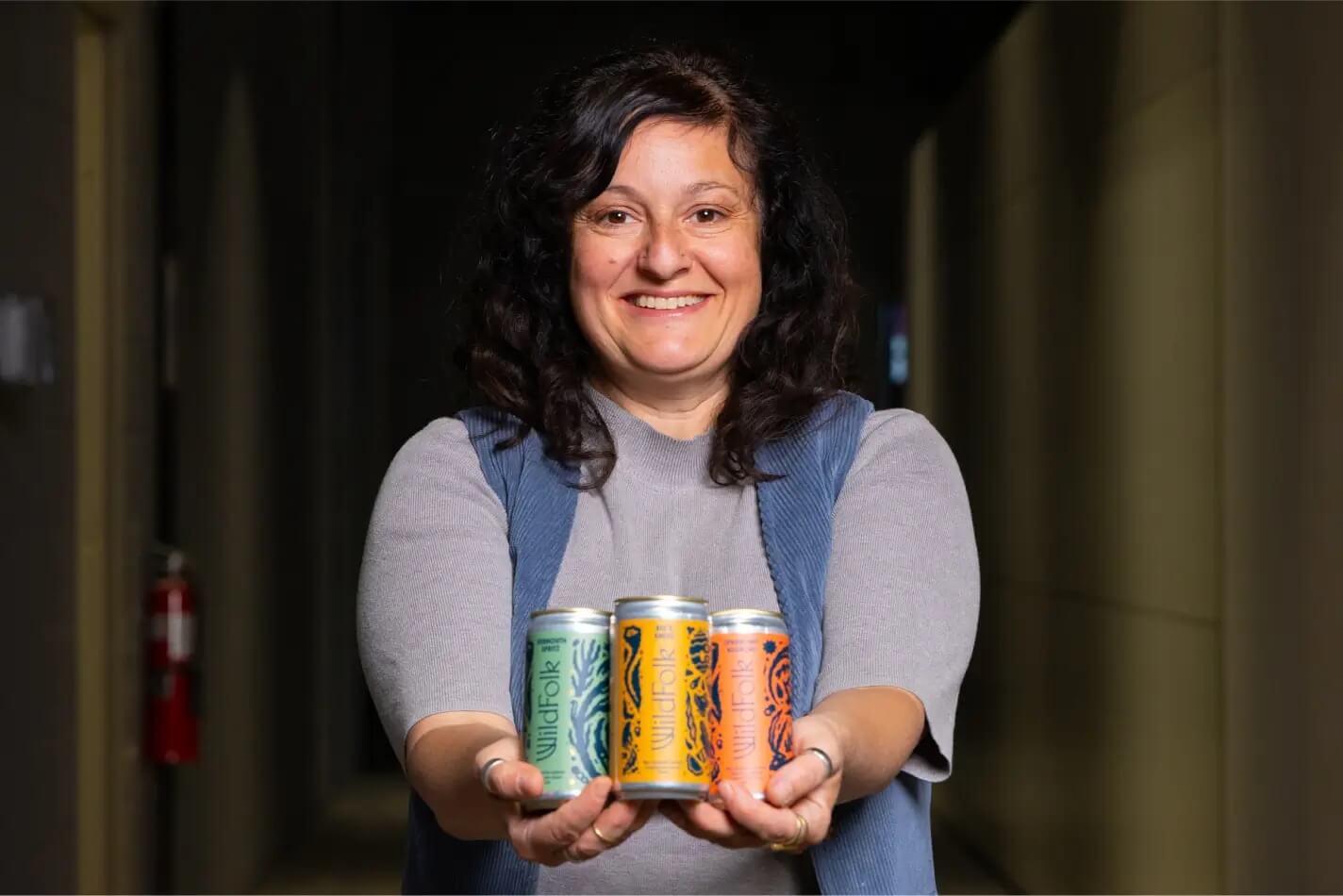 Woman holding cans of Wild Folk cocktails