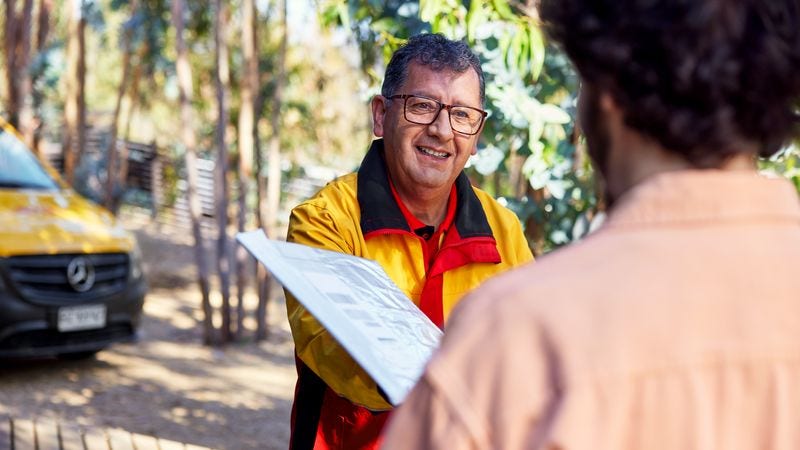 a dhl employee handing over an envelope to a customer