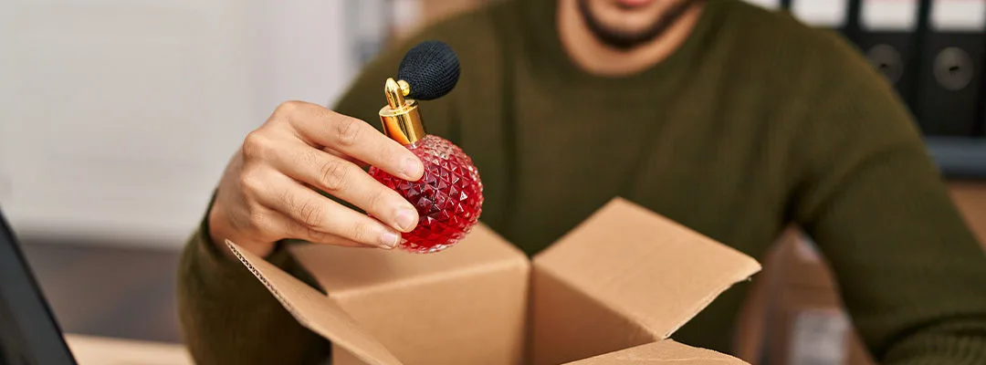 man placing perfume bottle in box