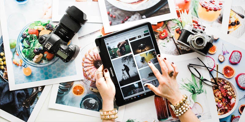 Cameras with photographs of food and woman holding tablet