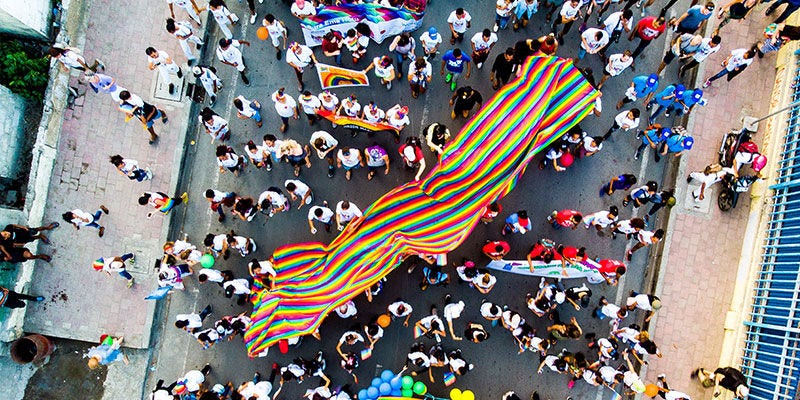 people walking in a street holding a flag