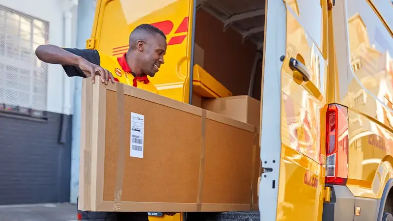 dhl courier putting parcel in van