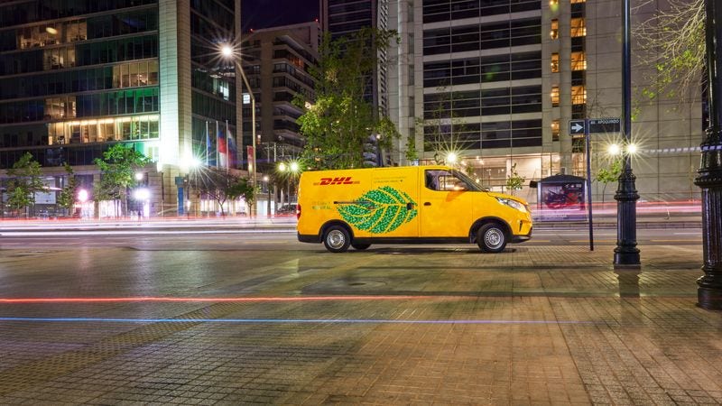 electric dhl express vehicle delivering packages in the city