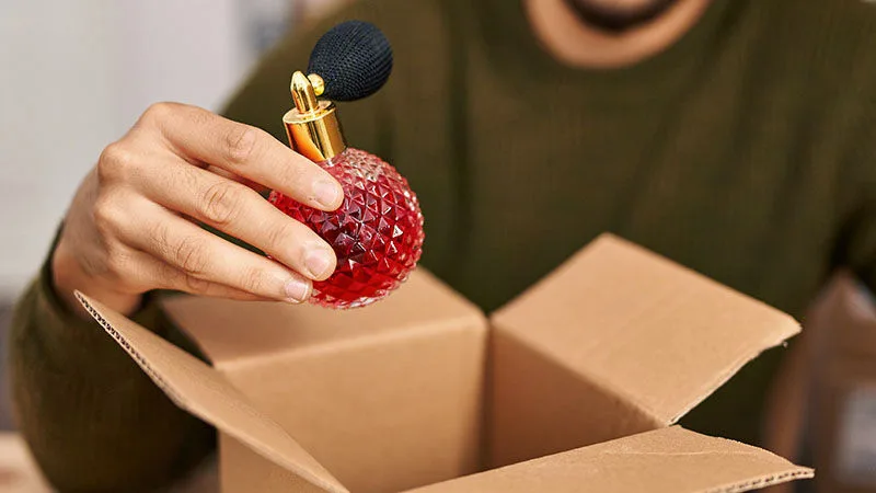 hand holding red perfume bottle