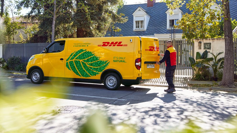 A DHL employee opening the van’s rear door.