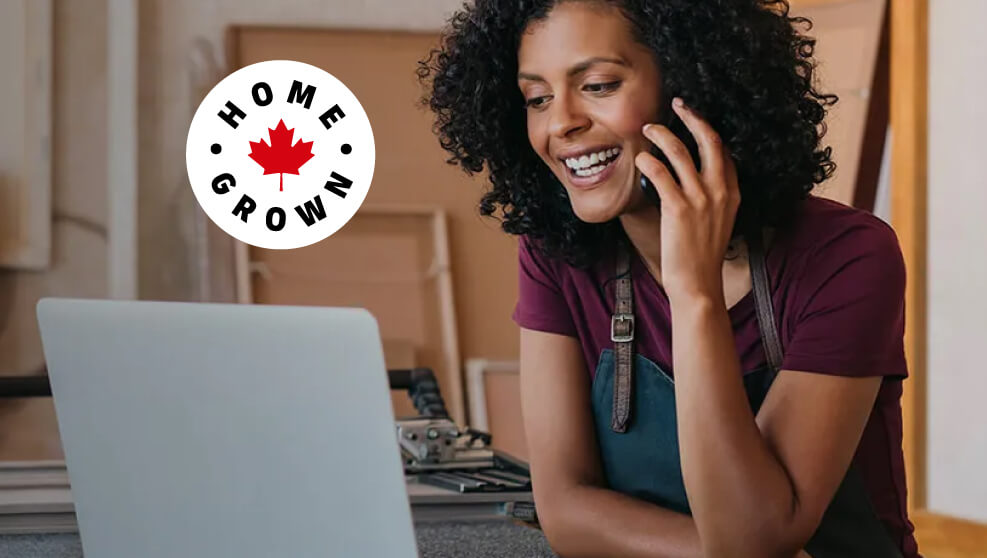 Woman talking on the phone while looking at her laptop