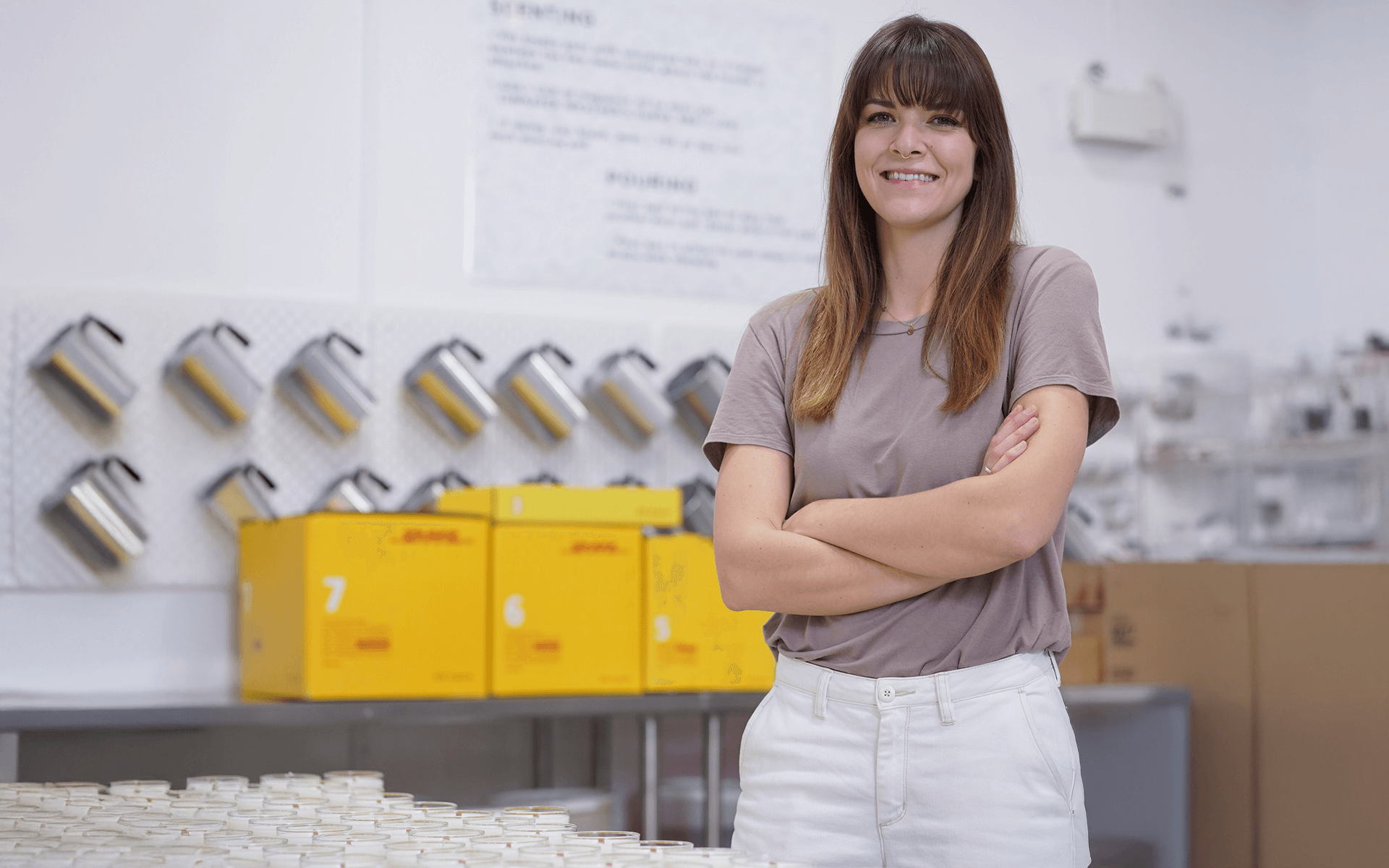 Holly Singer, the owner of Milk Jar, poses with some of her candles