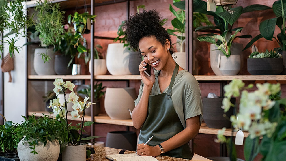 woman smiling and writing in a notebook