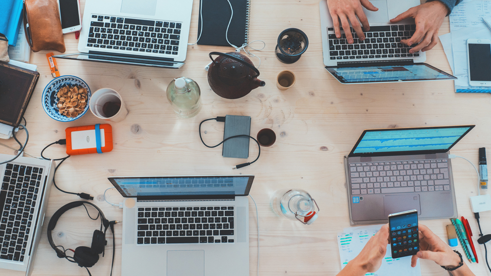 various hands typing on laptops