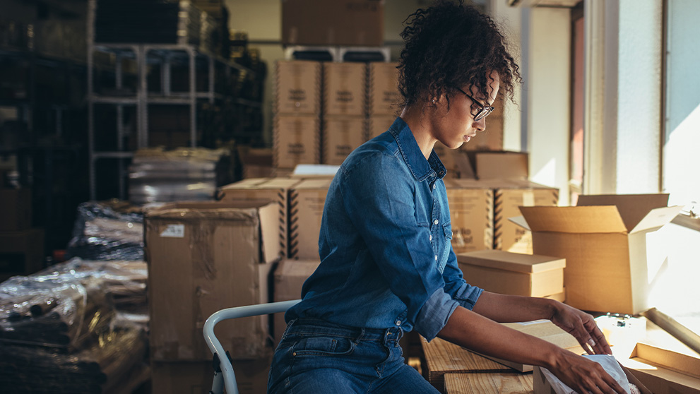 woman labelling parcels in storage room