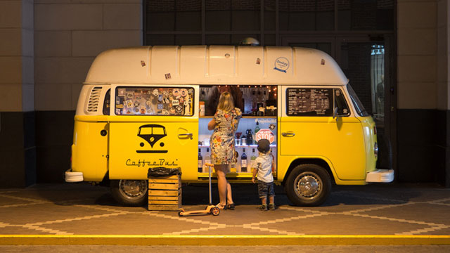 Woman and boy standing outside yellow food van