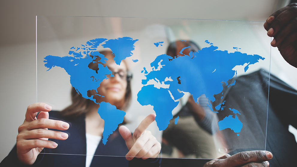 man and woman looking at map of the world