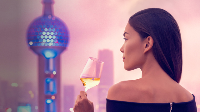 Young woman drinking wine on a Chinese rooftop