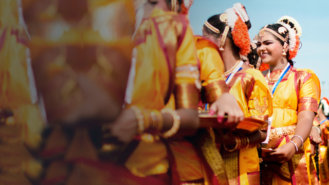 women in orange smiling in a row