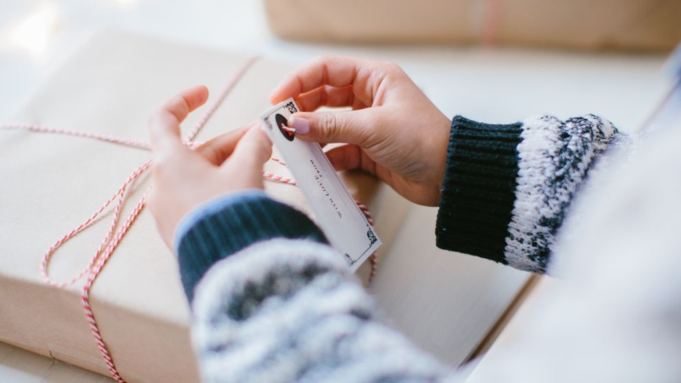 woman packing a gift box securely to minimize shipping delays during e-commerce peak season