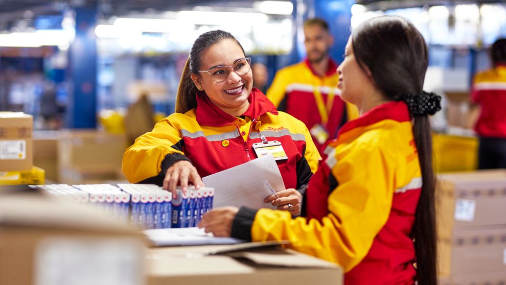 DHL Express employees inspecting the goods in preparation for international shipping