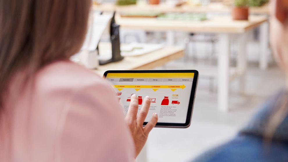 a person checking dhl shipping solutions on a tablet during a consultation