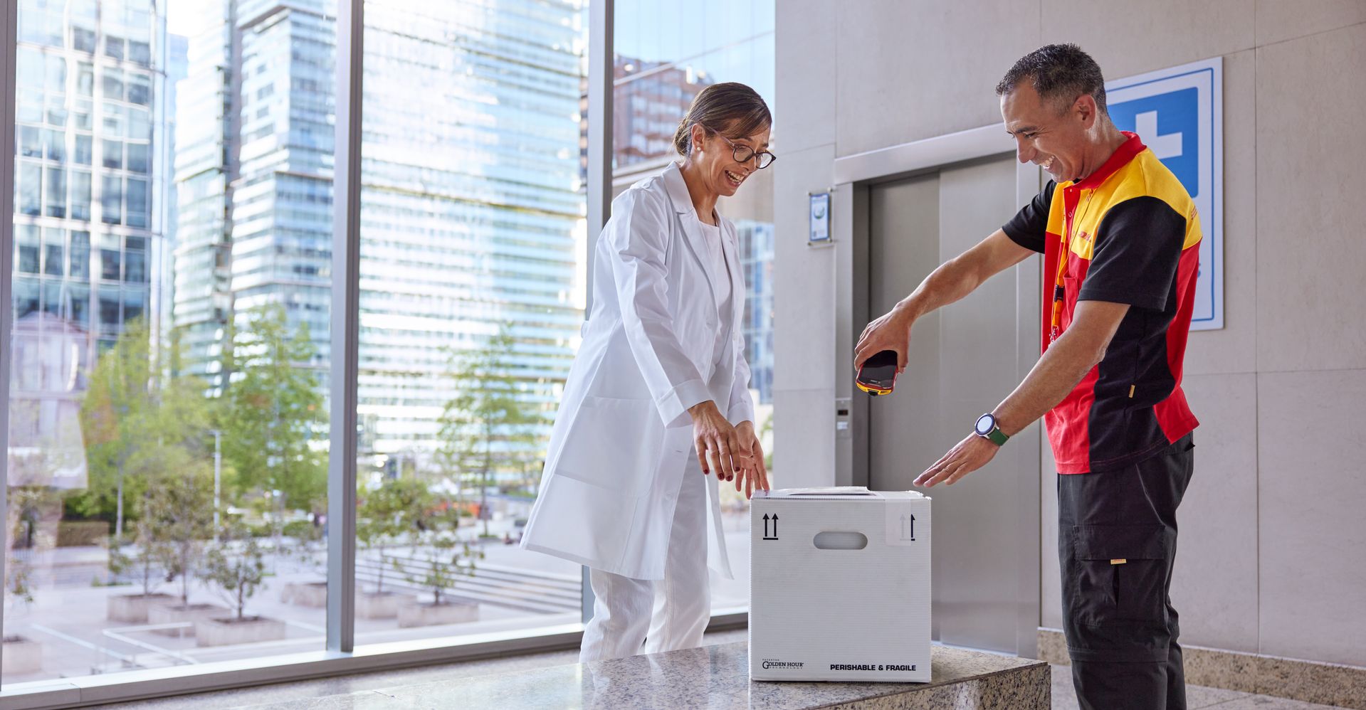 DHL employee is scanning a delivery next to a female customer working in the medical sector