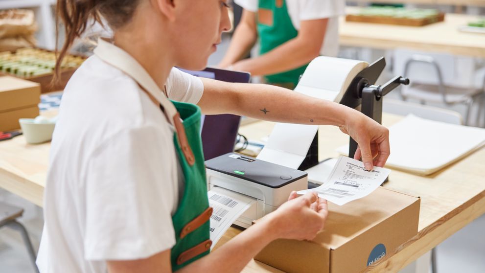 a female employee pasting a shipping label on a parcel