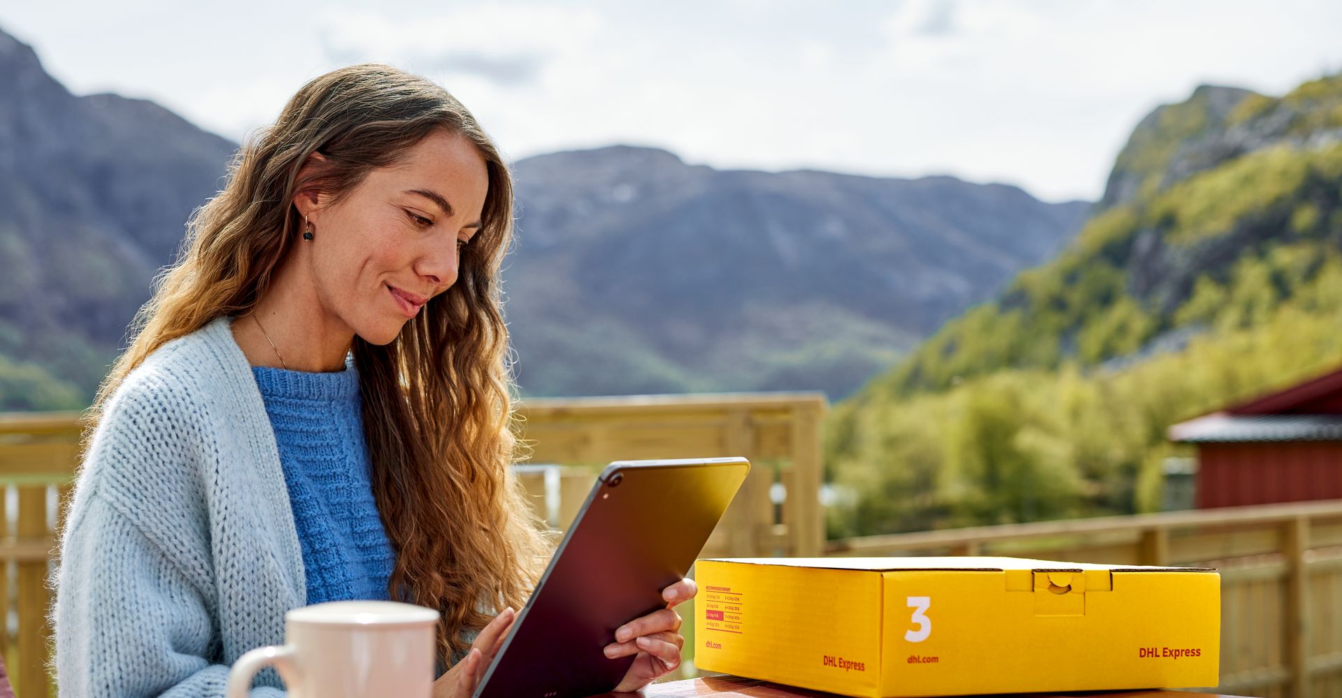 female customer browsing on tablet with DHL parcel