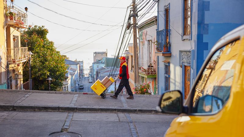 Backview of a male DHL employee delivering parcels in Saudi Arabia