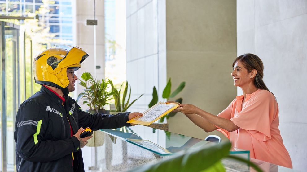 woman passing an important document for shipping to a DHL Express courier