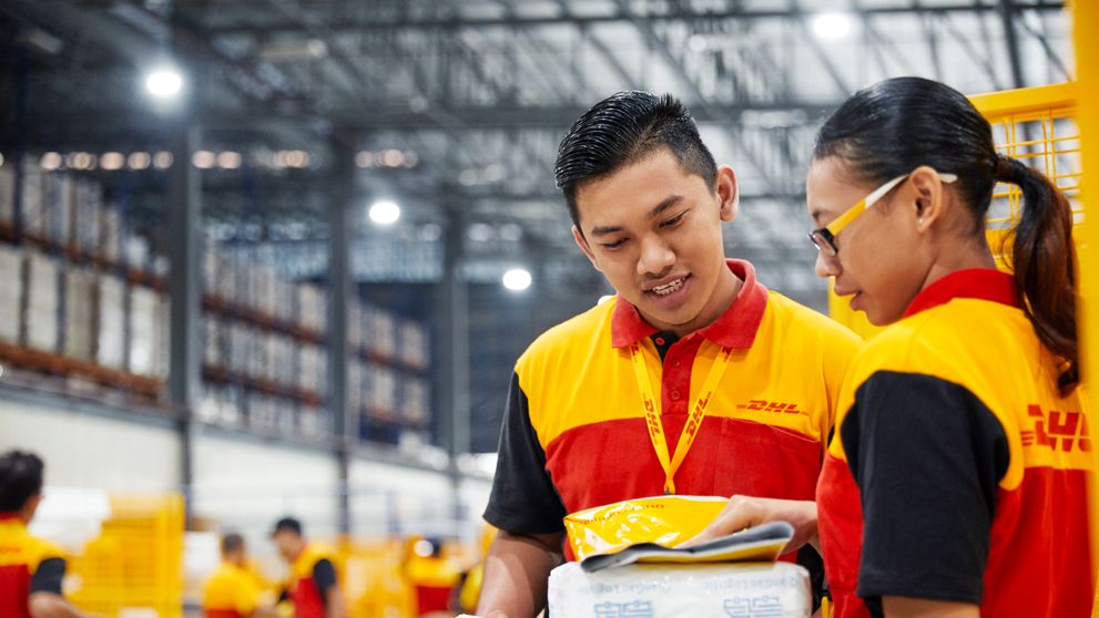 two dhl express employees from thailand preparing to sort parcels for export